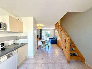 a kitchen with a staircase leading to a dining room at Les Deux Terrasses, 6 pers Piscine à Calvisson in Calvisson