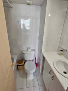 une salle de bain blanche avec toilettes et lavabo dans l'établissement Departamento Teatinos Santiago Centro, à Santiago
