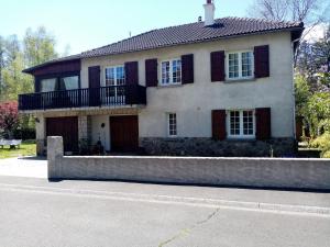 a large white house with a balcony on a street at petunias in Vic-sur-Cère