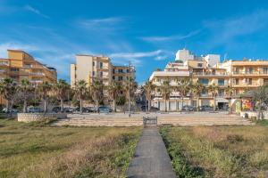 a path in a city with buildings and palm trees at Sea House a due passi dal mare in Pozzallo