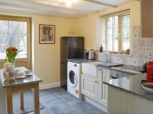 a kitchen with a washer and dryer in it at The Old Sawmill Sunnyside in Dobwalls +12 photos