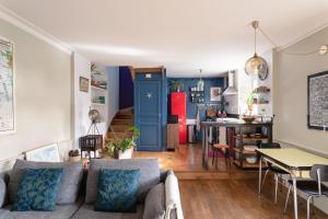 a living room with a couch and a kitchen at Cottage Thabor - Centre de Rennes in Rennes
