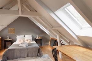 a attic bedroom with a bed and a wooden table at Cottage Thabor - Centre de Rennes in Rennes