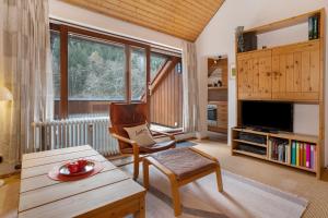 een woonkamer met een tv, een stoel en een tafel bij Kuckucksnest in Bad Herrenalb