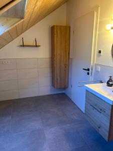 a bathroom with a sink and a wooden door at Holzliebe mit Donaublick in Kaisheim +17 photos