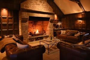 een woonkamer met banken en een stenen open haard bij Rachel’s Farm, Glenalmond in Inchture