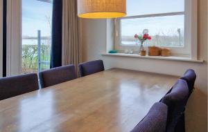 a dining room with a table and chairs and a window at Bodelaeke-Wiedenwoning in Giethoorn