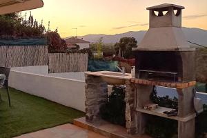 una cocina al aire libre con fregadero en el patio trasero en Ca la Nena Morena - Refugio cálido con chimenea y vistas al Montseny, en Vallgorguina