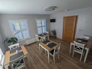 a living room with tables and chairs and a door at Gateside Lodge in Portrush