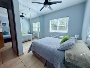 a bedroom with a bed and a ceiling fan at Ocean Terrace 202 a 4 min walk to Sandy Beach in Aguada +12 photos
