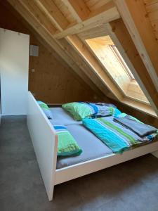 een bed in een zolderkamer bij Holzliebe mit Donaublick in Kaisheim +22 foto's