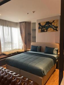 a bedroom with a large bed and a couch at Once Pattaya Top Luxury Condo in the City Center in Pattaya Central +21 photos