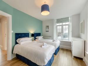 two beds in a room with blue and white at Silverdale Apartment in Lindale