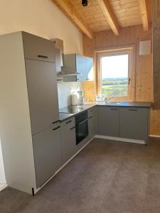 a kitchen with stainless steel appliances and a window at Holzliebe mit Donaublick in Kaisheim