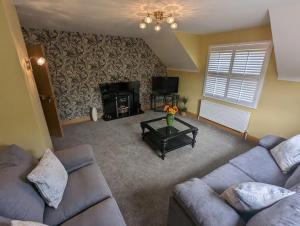 a living room with a couch and a fireplace at Gateside Lodge in Portrush
