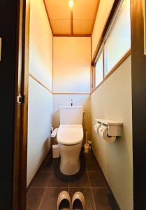 a bathroom with a toilet with a window and a pair of shoes at Takemi no Yado - Vacation STAY 97130v in Yufuin +25 photos