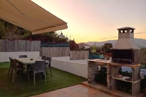 a outdoor patio with a table and a grill at Ca la Nena Morena - Casa con piscina privada, jardín y vistas al Montseny in Vallgorguina +35 photos