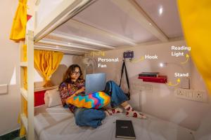 a woman sitting on a bed with a laptop at goSTOPS Amritsar, Chatiwind Gate in Amritsar +15 photos