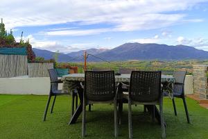 a table and chairs with a view of a mountain at Ca la Nena Morena - Casa con piscina privada, jardín y vistas al Montseny in Vallgorguina