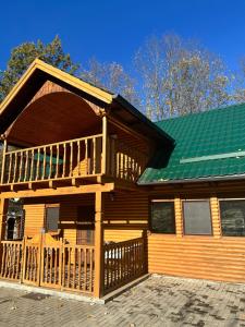 卡兰塞贝什Casa ANE的一座带绿色屋顶的大型木制房屋