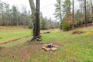 eine Feuerstelle in einem Feld neben einem Baum in der Unterkunft Hot Tub & WiFi -Carrie's Cottage - Red River Gorge in Pine Ridge