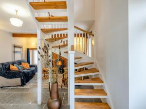 eine Wendeltreppe in einem Wohnzimmer mit einem Sofa in der Unterkunft Ivy Bush Cottage in Llanddewi-Brefi