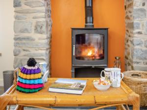 ein Couchtisch aus Holz mit einem Buch und einem Kamin in der Unterkunft Ivy Bush Cottage in Llanddewi-Brefi