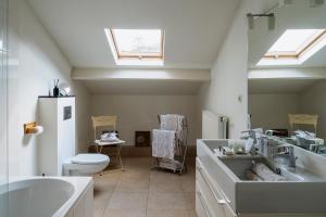 a bathroom with a sink and a toilet and a tub at B&B Hof van Vervoering in Voeren +65 photos