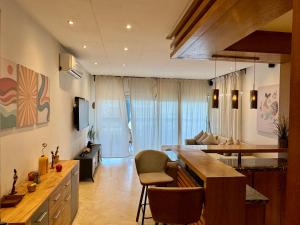 Una cocina y una sala de estar con mesa y sillas. en Peninsula Dar Bouazza Superbe appartement en résidence avec piscine activités, en Dar Bouazza