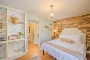 een slaapkamer met een wit bed en een houten muur bij Downtown Oasis Family Home - Lawrence University PAC College Ave in Appleton