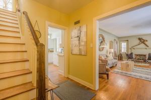 een woonkamer met gele muren en een trap bij Downtown Oasis Family Home - Lawrence University PAC College Ave in Appleton