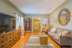 een woonkamer met een bank en een tv bij Downtown Oasis Family Home - Lawrence University PAC College Ave in Appleton