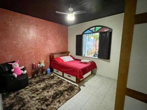 Un dormitorio con una cama roja y una ventana. en Rent cop30 Belém For Mosqueiro Praia Grande, en Belém