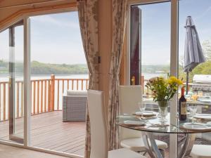 a dining room with a balcony with a table and chairs at Badger Lodge in Burton