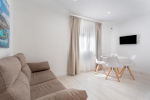 ein Wohnzimmer mit Sofa und Tisch in der Unterkunft Martianez Luxury Vista in Puerto de la Cruz