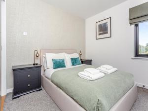 Un dormitorio con una cama con toallas. en The Peaks, en Aviemore