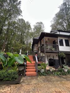 a house with a staircase in front of it at Woodsy home near Wineries, Hiking, & River in Dahlonega
