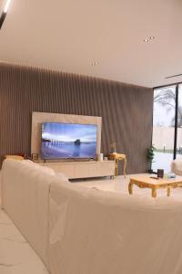 a living room with a large couch and a flat screen tv at B&B Villa in Ras al Khaimah