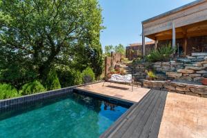 a swimming pool with a chair next to a house at Maisonk Provence in Villedieu +19 photos