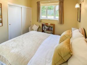 une chambre avec un grand lit blanc avec deux oreillers dans l'établissement Blossom's Cottage, à Albourne