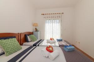 a bedroom with two beds and a window at Rocha Retreat - Praia Da Rocha in Portimão +17 photos