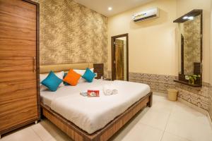 a bedroom with a large bed with colorful pillows at goSTOPS Amritsar, Chatiwind Gate in Amritsar