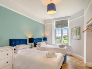 two beds in a bedroom with a window at Kent View Apartment in Lindale +8 photos