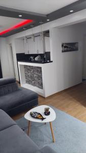 un soggiorno con un divano e un tavolo di Apartment Marković a Bijeljina Altre 8 foto