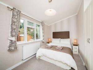 a bedroom with a large bed and two windows at Thistle Lodge in Auchterarder