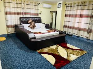 a bedroom with a bed with a black leather headboard at Hotel Green View in Ilām +3 photos