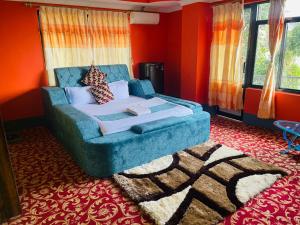 a living room with a blue couch and orange walls at Hotel Green View in Ilām