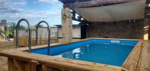 a swimming pool on a deck with a wooden fence at Mas Des Genêts in Laurac-en-Vivarais