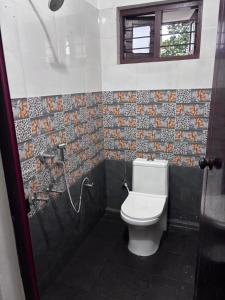 ein Badezimmer mit Toilette und Fenster in der Unterkunft Drifters Surf Eat Stay in Kappil