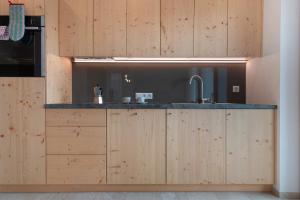 Una cocina con gabinetes de madera y un fregadero. en Prielerhof, en Chienes 54 fotos más